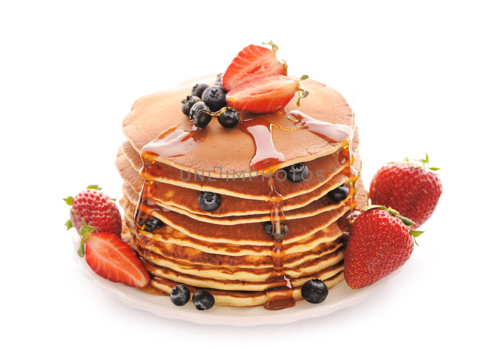 Delicious freshly prepared pancakes with strawberry and blueberries isolated on white