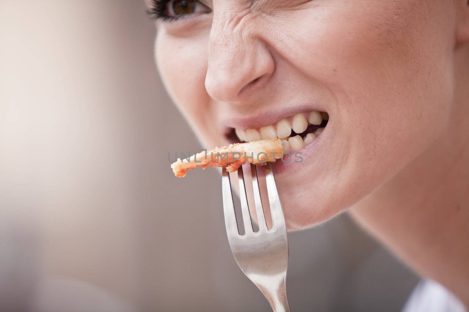 young woman is eating a pizza in restaurant outdoor