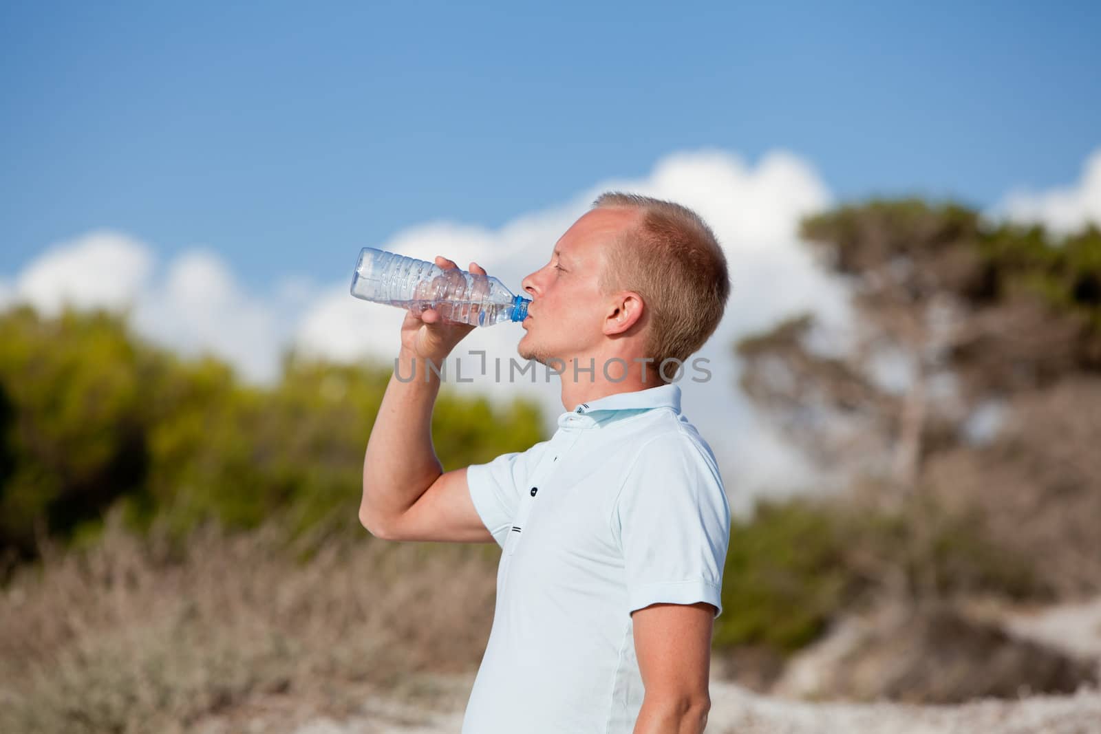 young man ist drinking water summertime dune beach sky by juniart