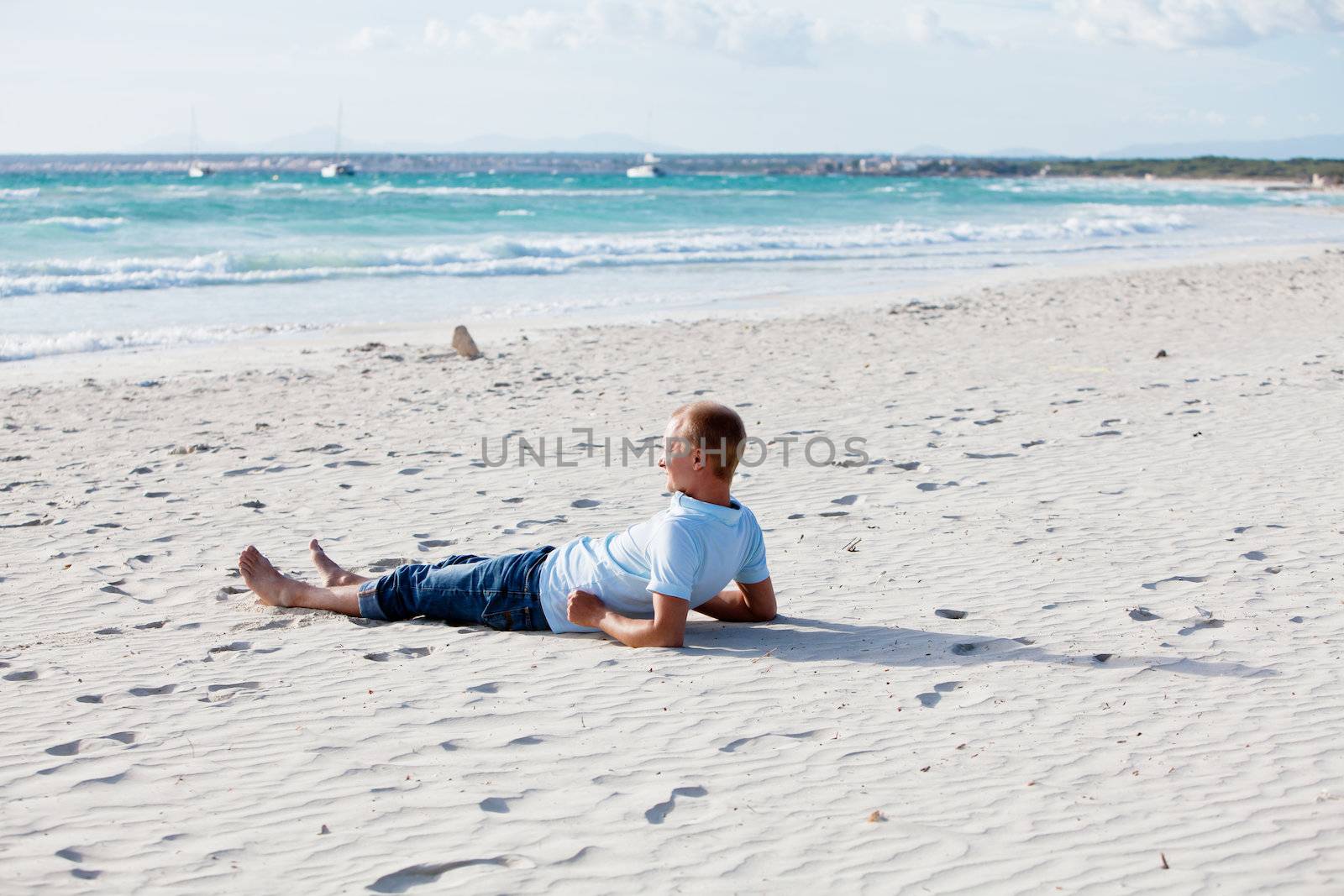 young man is relaxing on beach in summer vacation by juniart