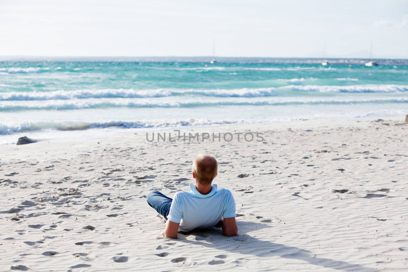 young man is relaxing on beach in summer vacation by juniart