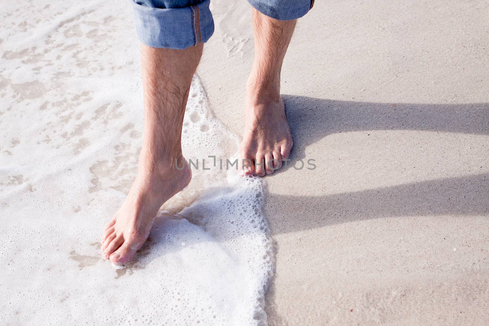 barefoot in sand and water on beach  in summer holidays relaxing