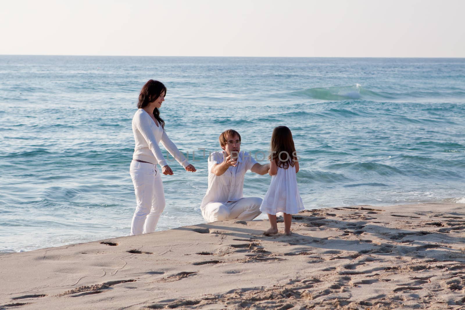 happy young family with daughter on beach in summer lifestyle