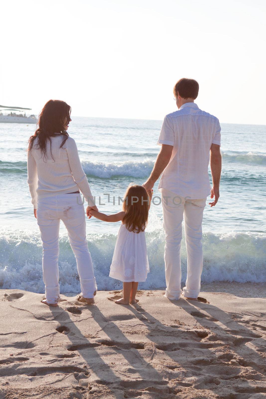 happy young family with daughter on beach in summer by juniart