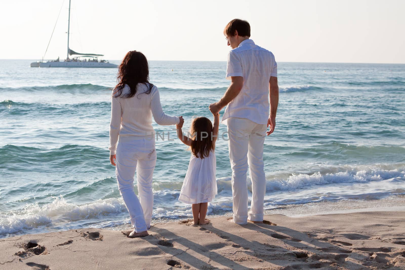 happy young family with daughter on beach in summer lifestyle