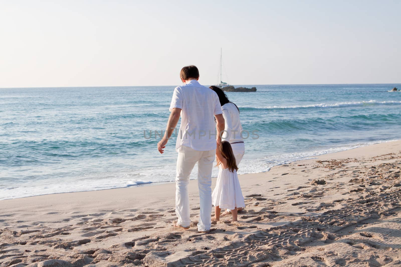 happy young family with daughter on beach in summer lifestyle