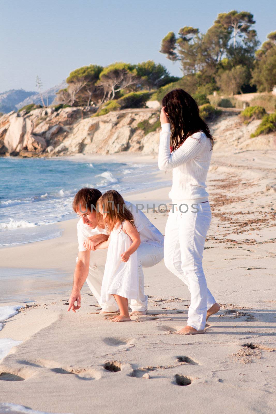 happy young family with daughter on beach in summer lifestyle