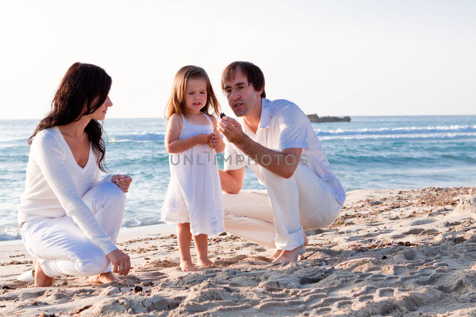 happy young family with daughter on beach in summer lifestyle