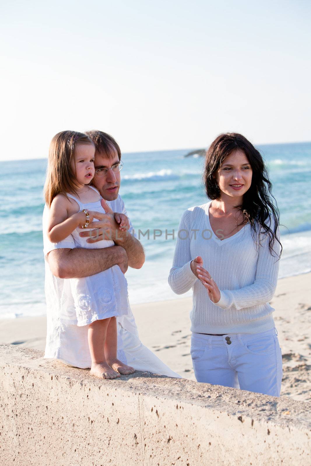 happy young family with daughter on beach in summer lifestyle