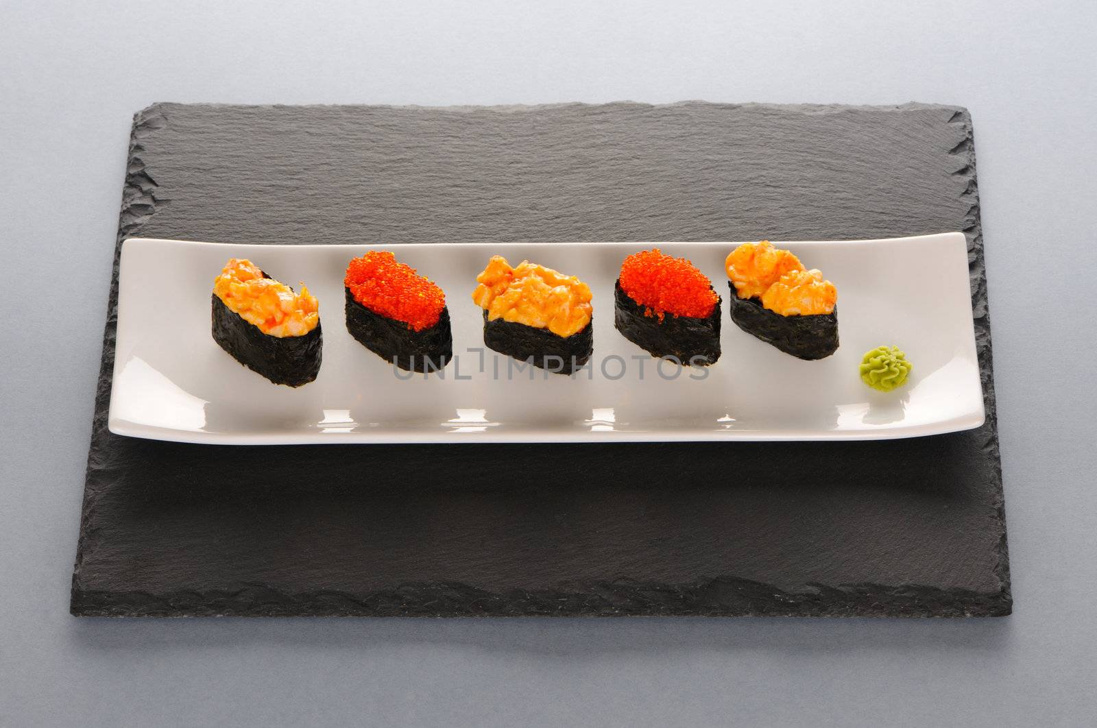 Tobiko and spice sushi on a slate plate