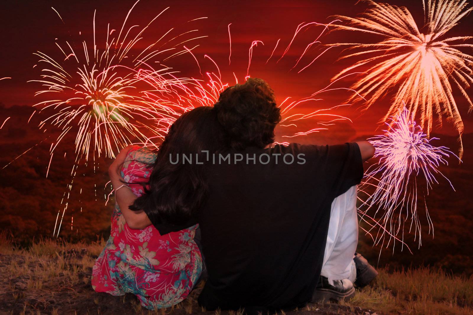 A romantic Indian couple watching traditional fireworks at dusk during the festive occassion of Diwali in India