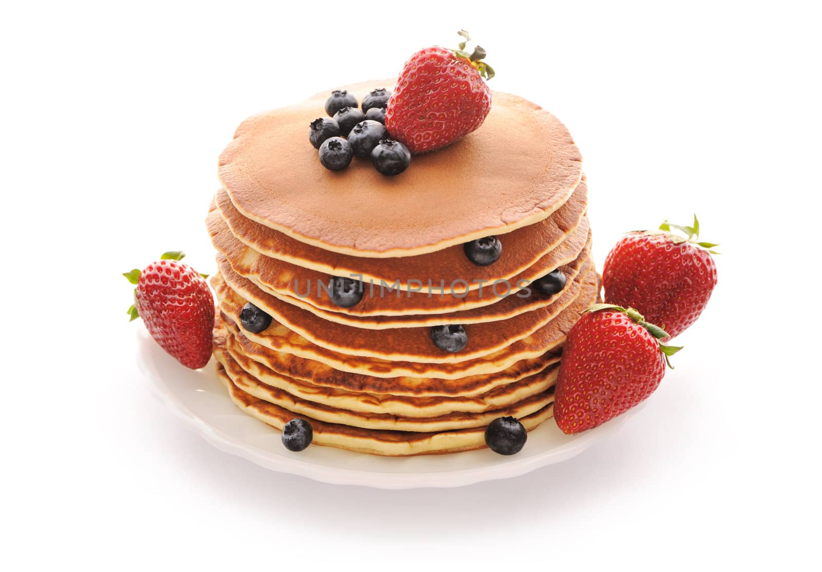 Delicious freshly prepared pancakes with strawberry and blueberries isolated on white