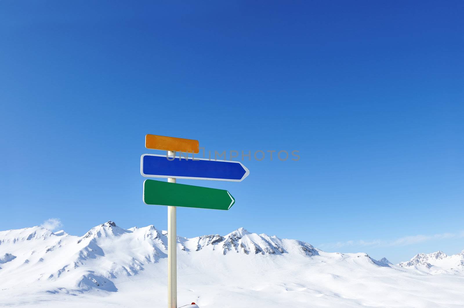 Arrow sign at mountains with snow in winter, Val-d'Isere, Alps, France