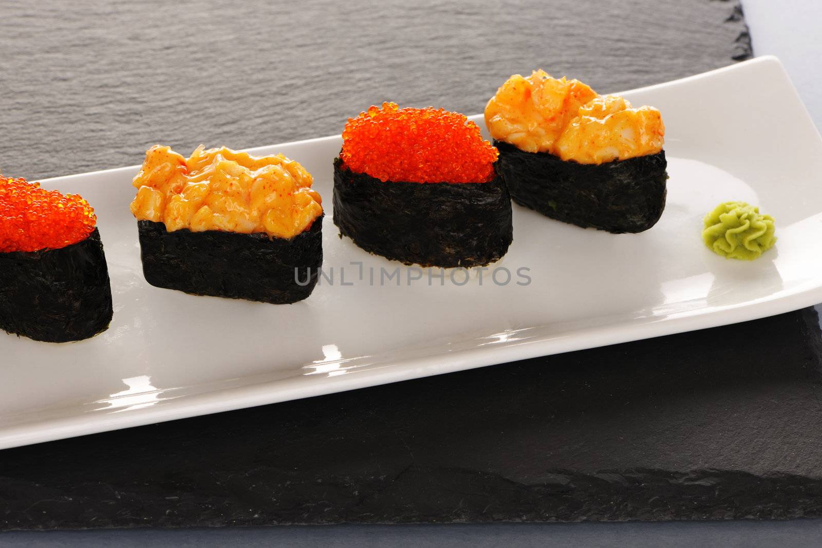 Tobiko and spice sushi on a slate plate