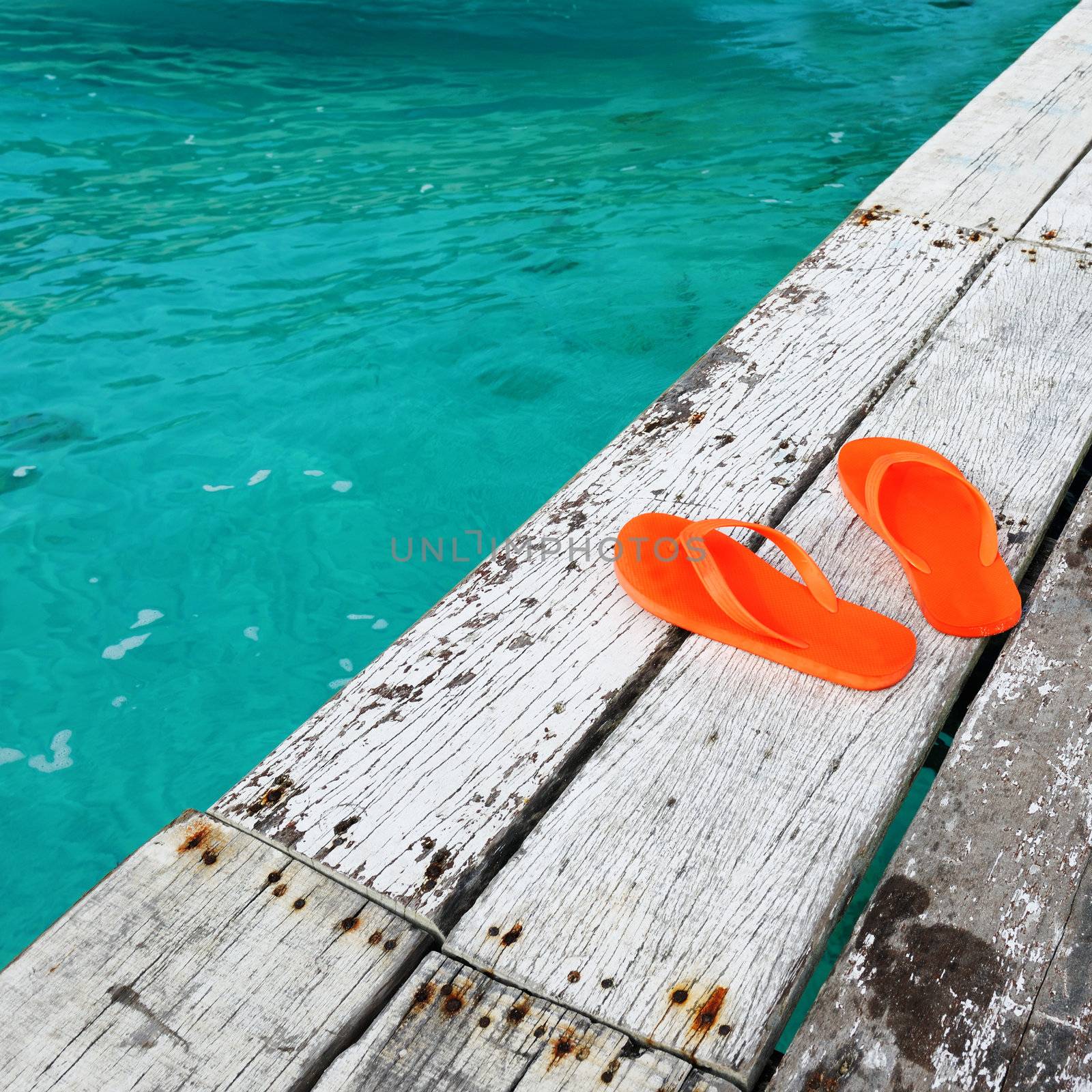Sandals at jetty by the sea