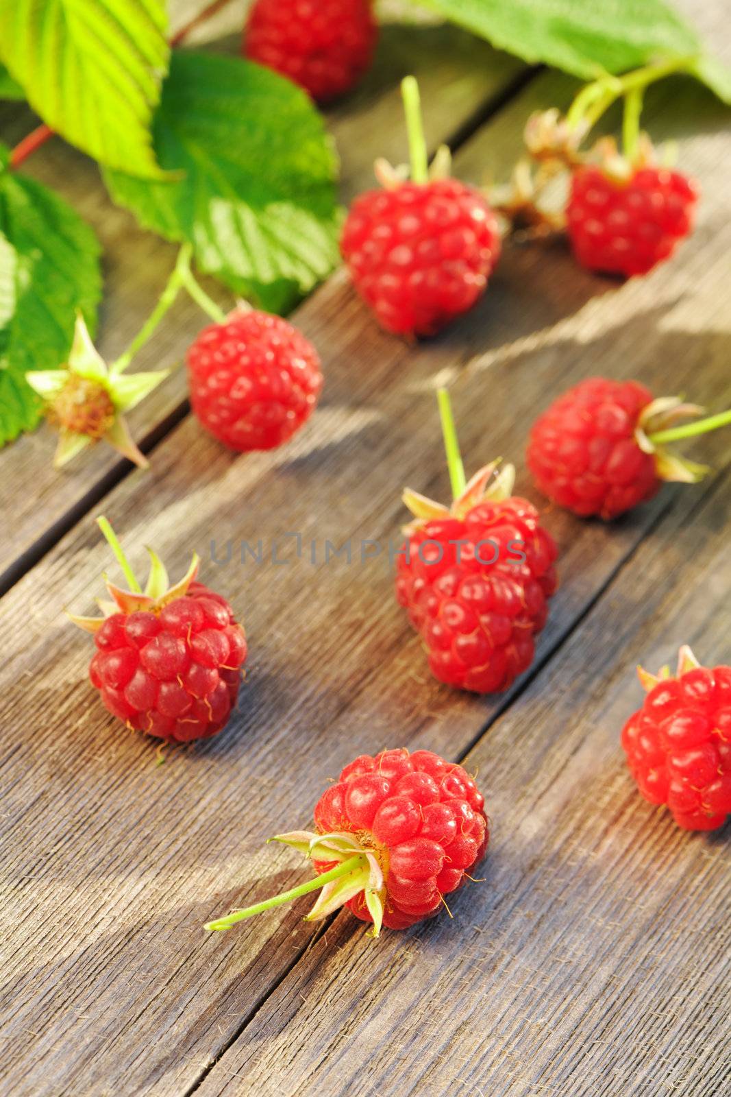 Raspberry with leafs on wooden table