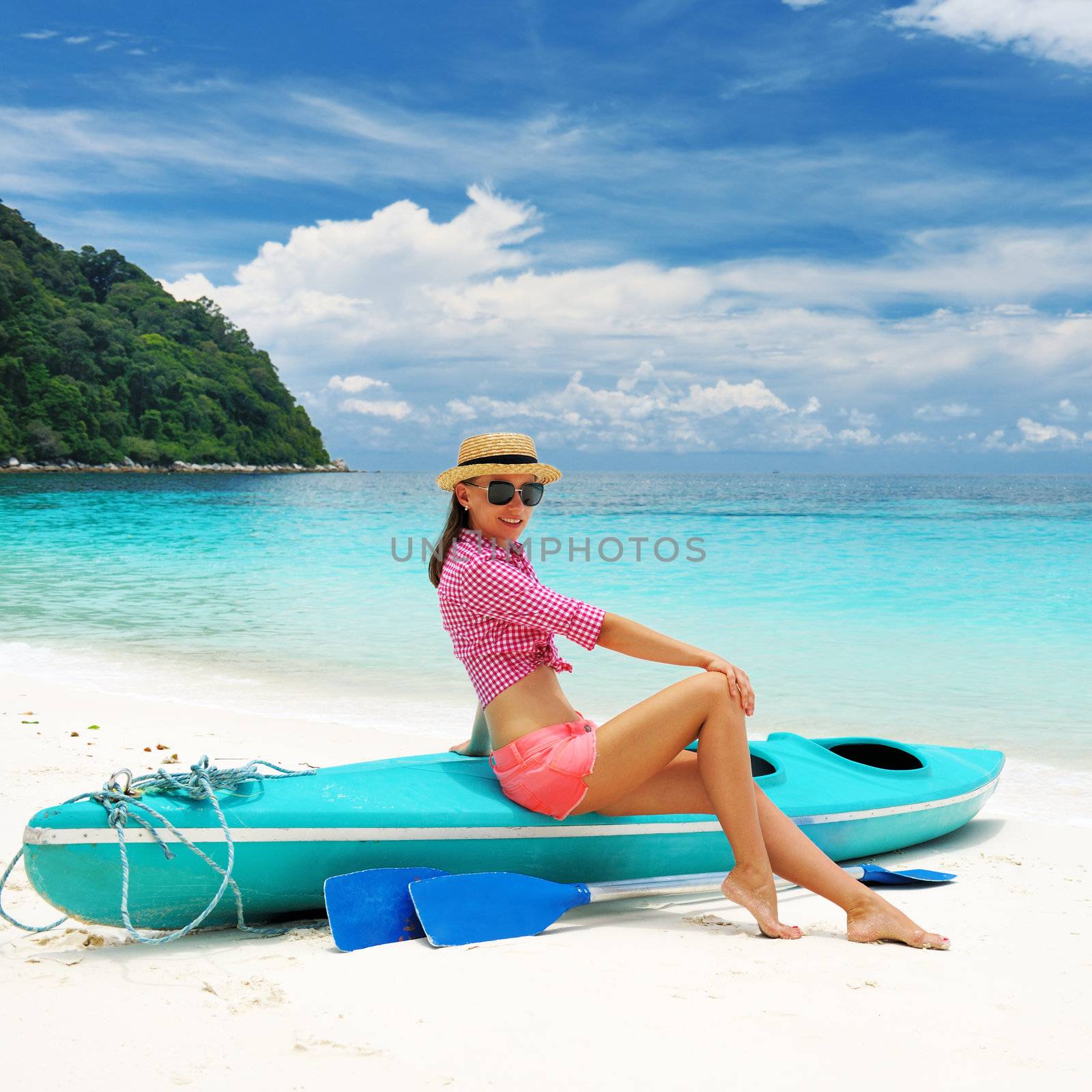 Woman in sunglasses at beach wearing hat
