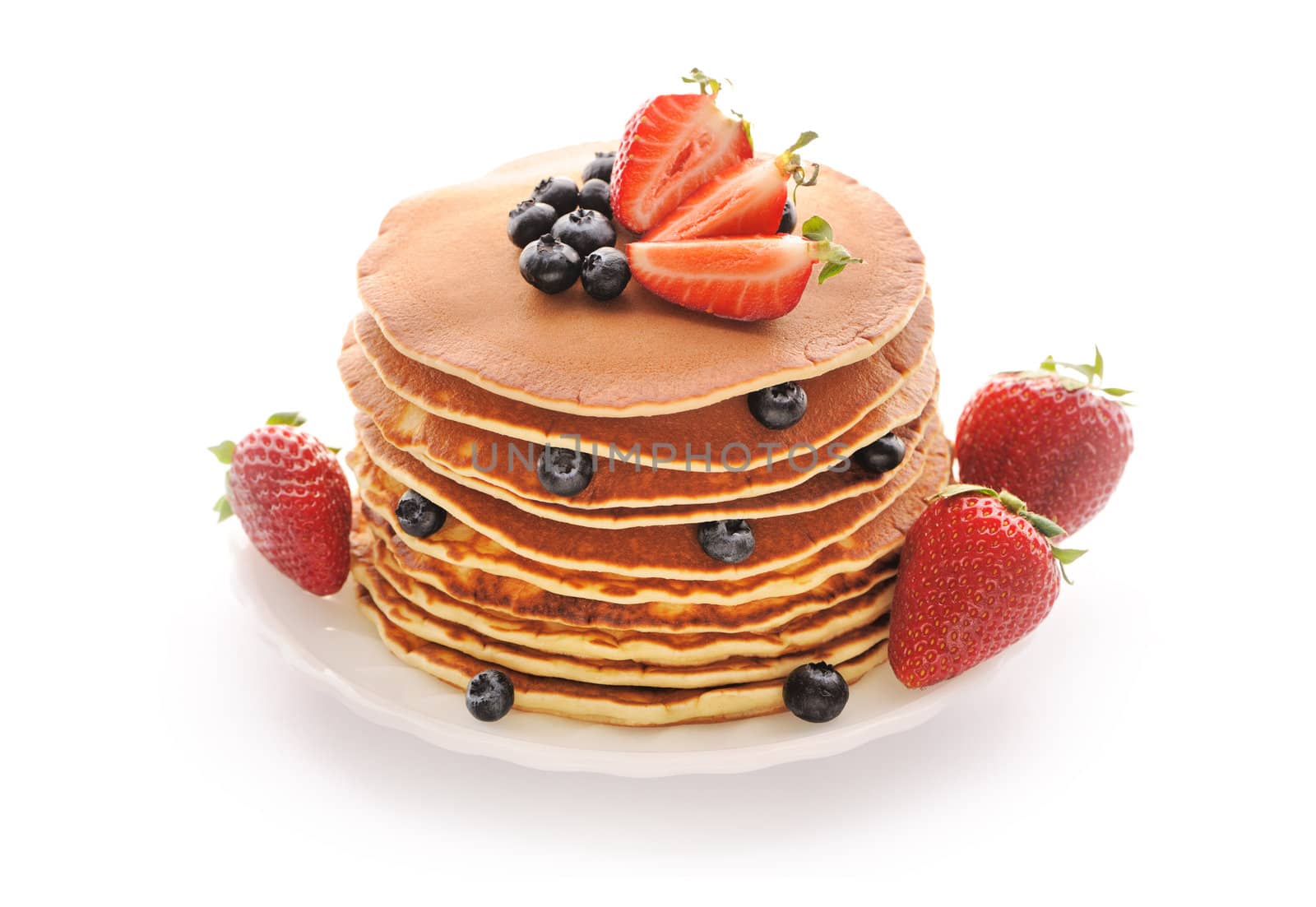 Delicious freshly prepared pancakes with strawberry and blueberries isolated on white