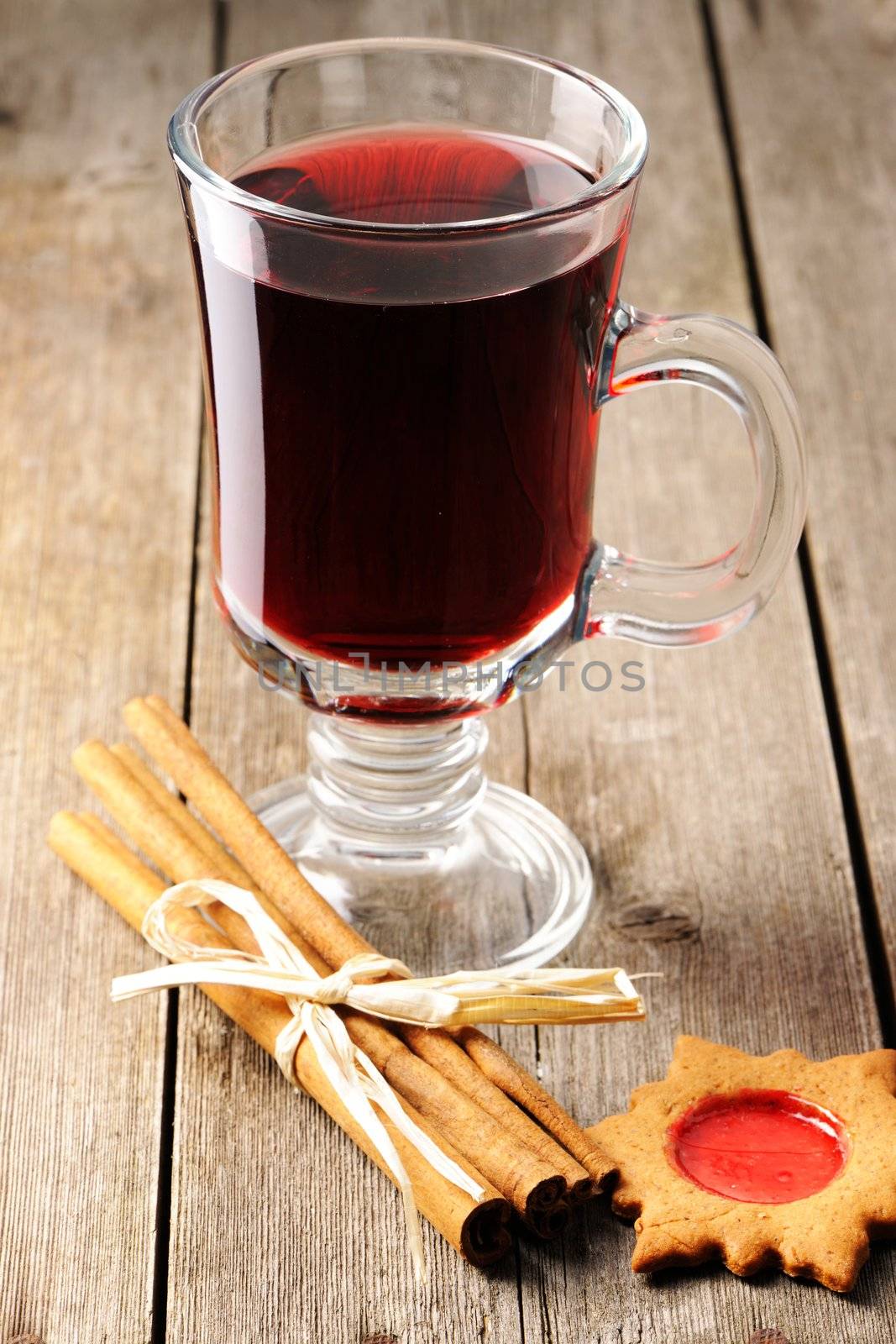 Glass of red mulled wine on wooden table