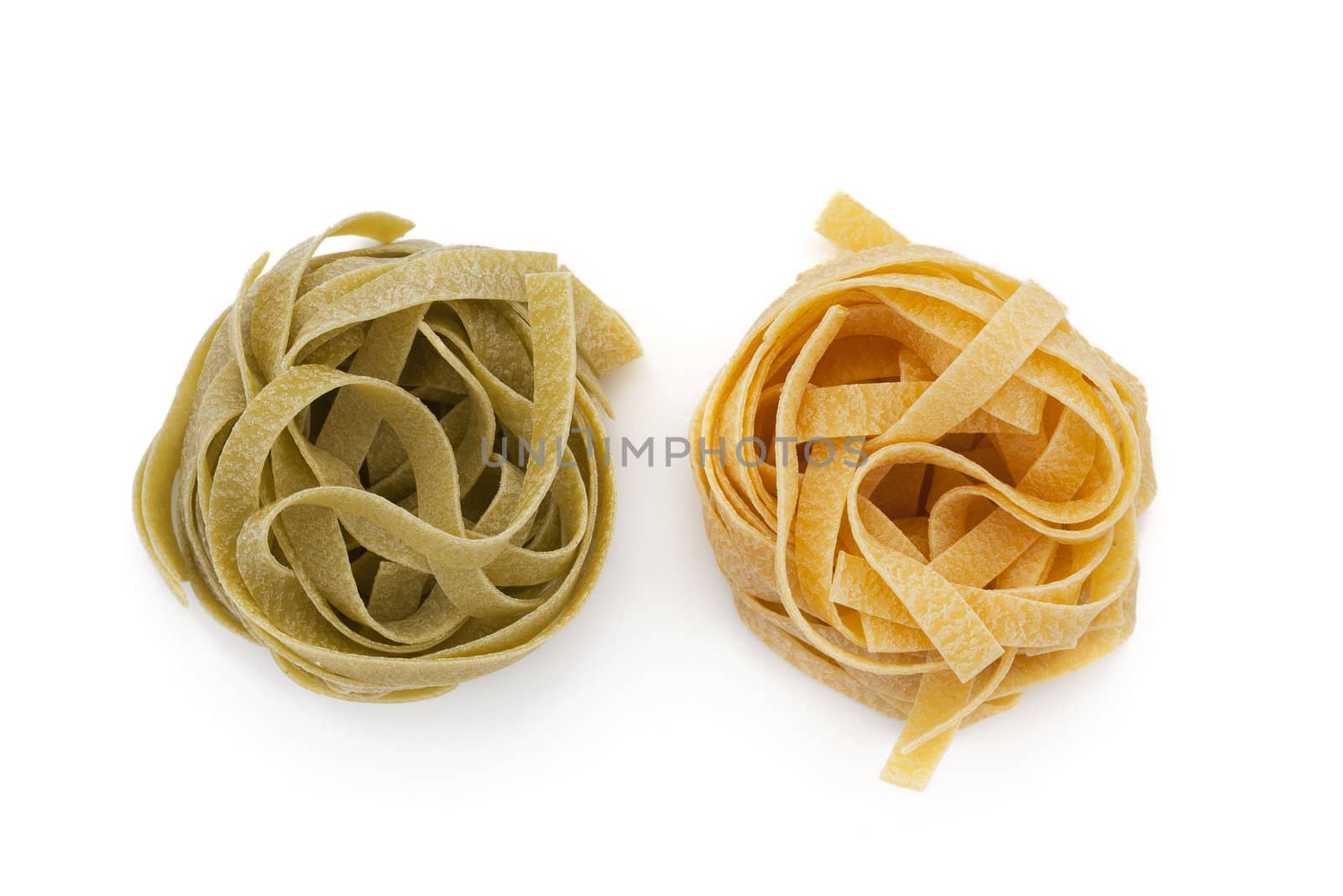 Two Tagliatelle nest, one green and one yellow on white background with shadows.