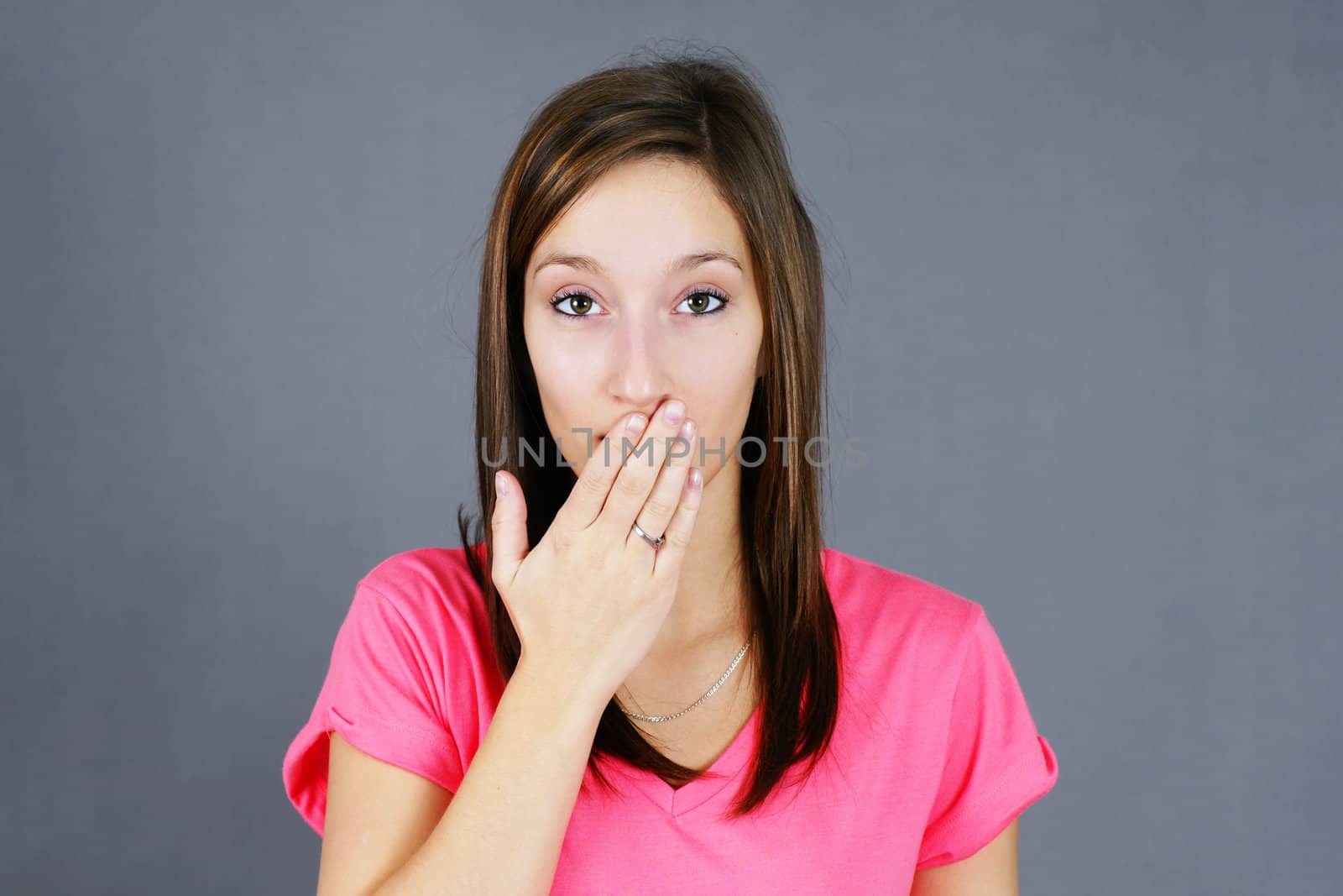 Cute young woman with hand over mouth, concept for secret, made a bad comment, oopsy, hush and others.