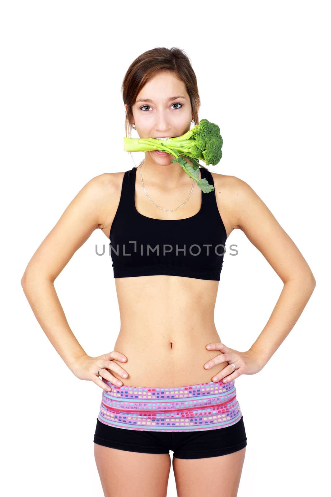 Humorous nutrition concept: slim, healthy and fit young woman with broccoli stalk in her mouth.