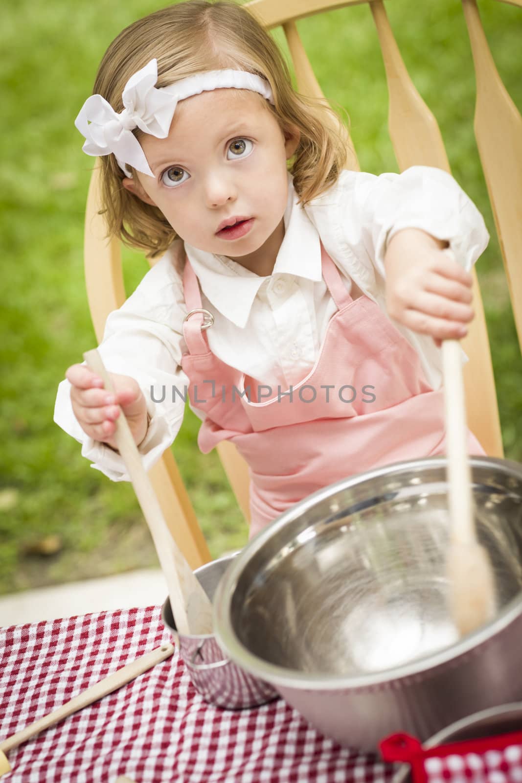 Happy Adorable Little Girl Playing Chef Cooking in Her Pink Outfit.