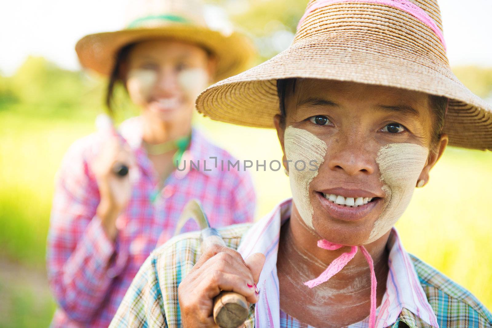 Portrait of a two Myanmar farmer with thanaka powdered face who works in the field