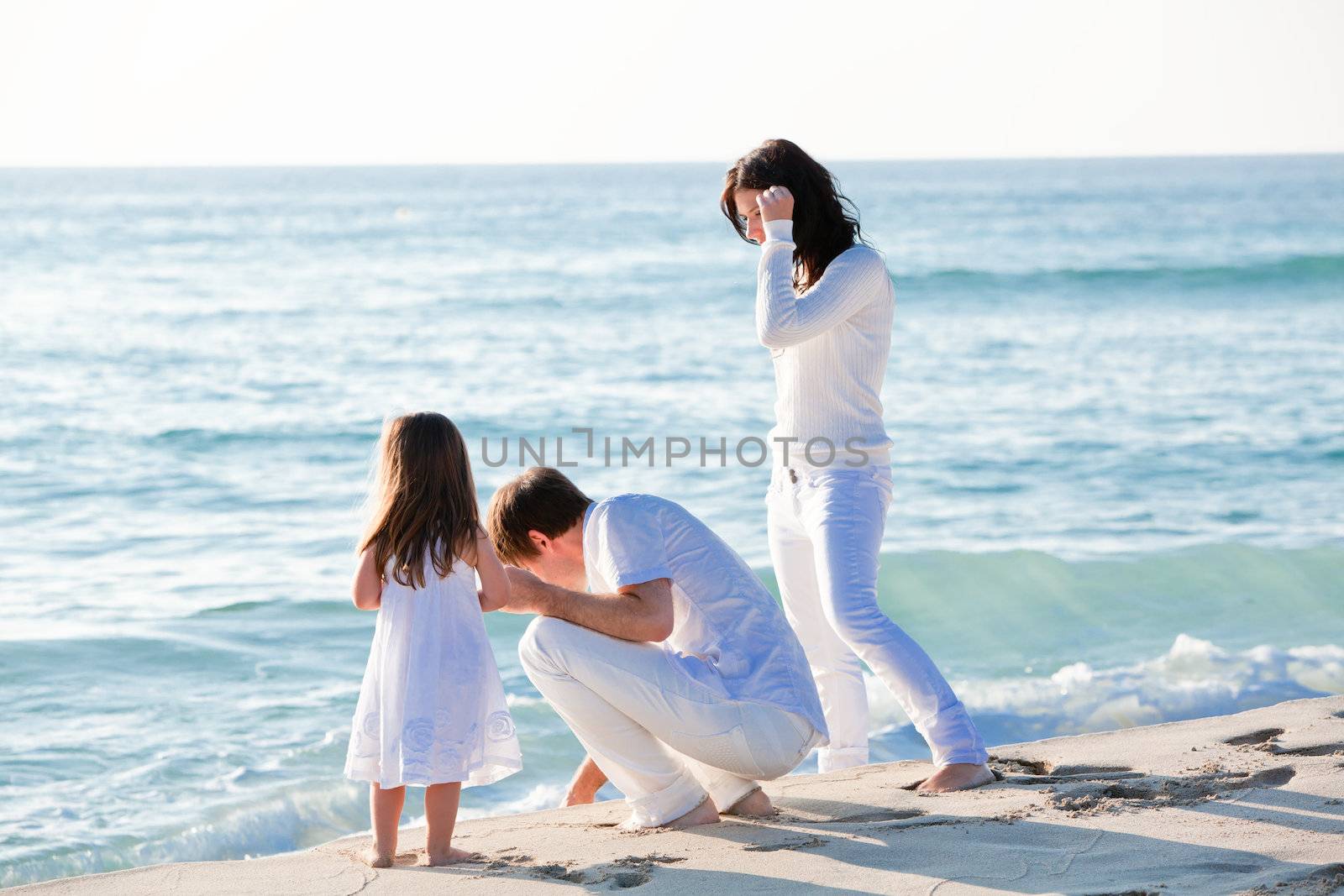 happy young family with daughter on beach in summer lifestyle