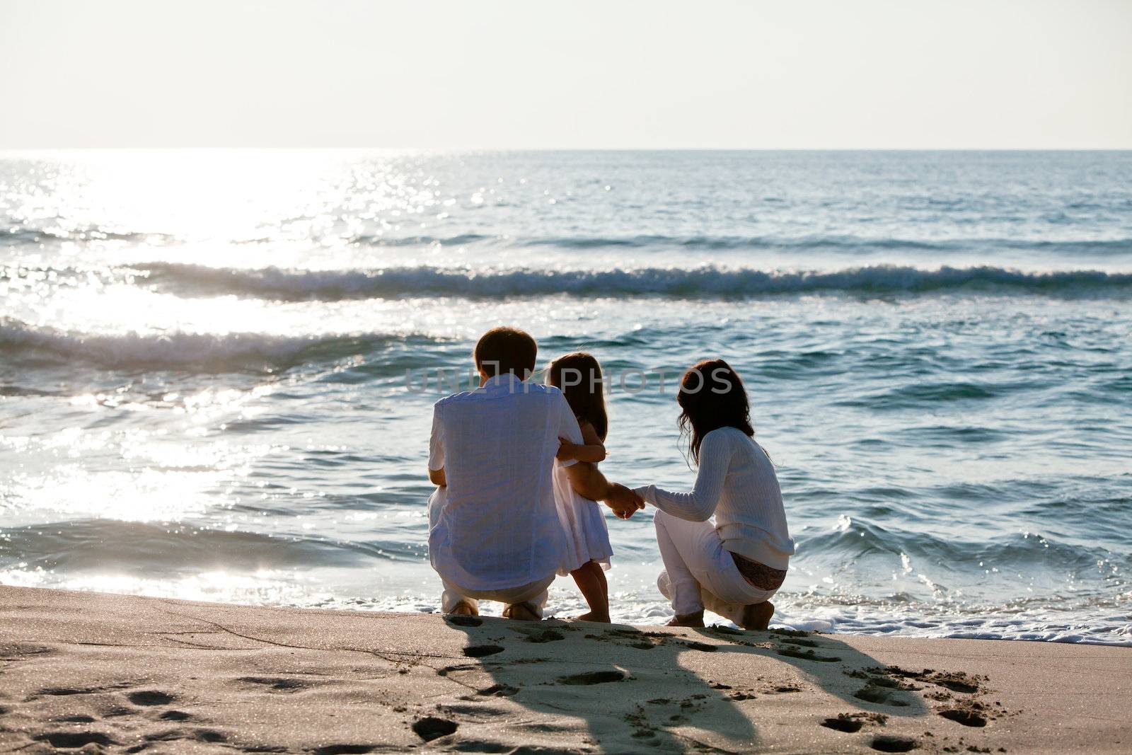 happy young family with daughter on beach in summer lifestyle