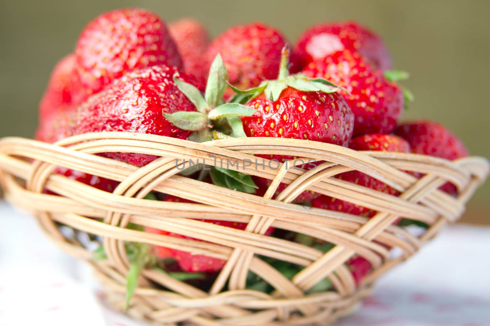 Fresh strawberries in a basket on a round table