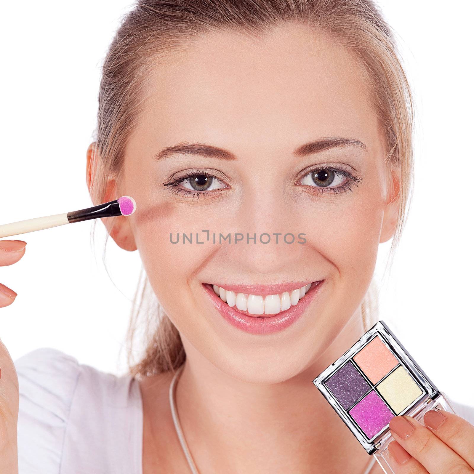 beautiful woman applying make up on face isolated on white