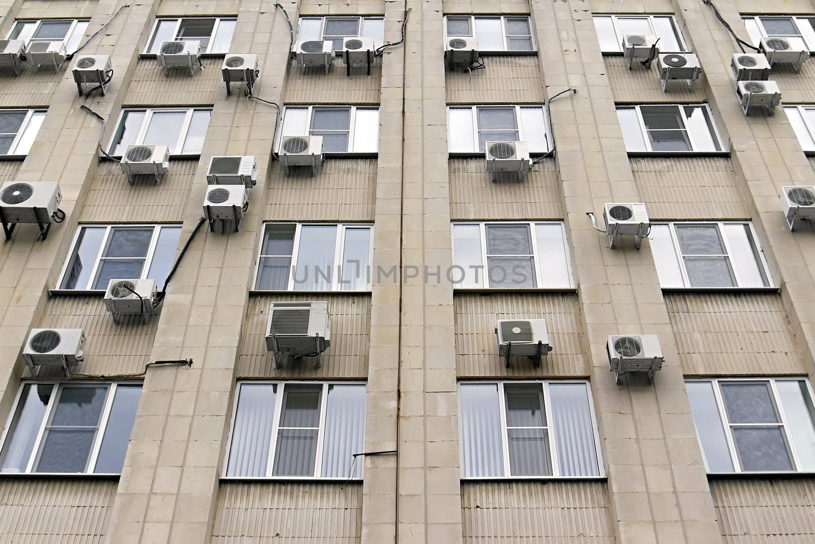 mani air conditioners on the building wall by Plus69