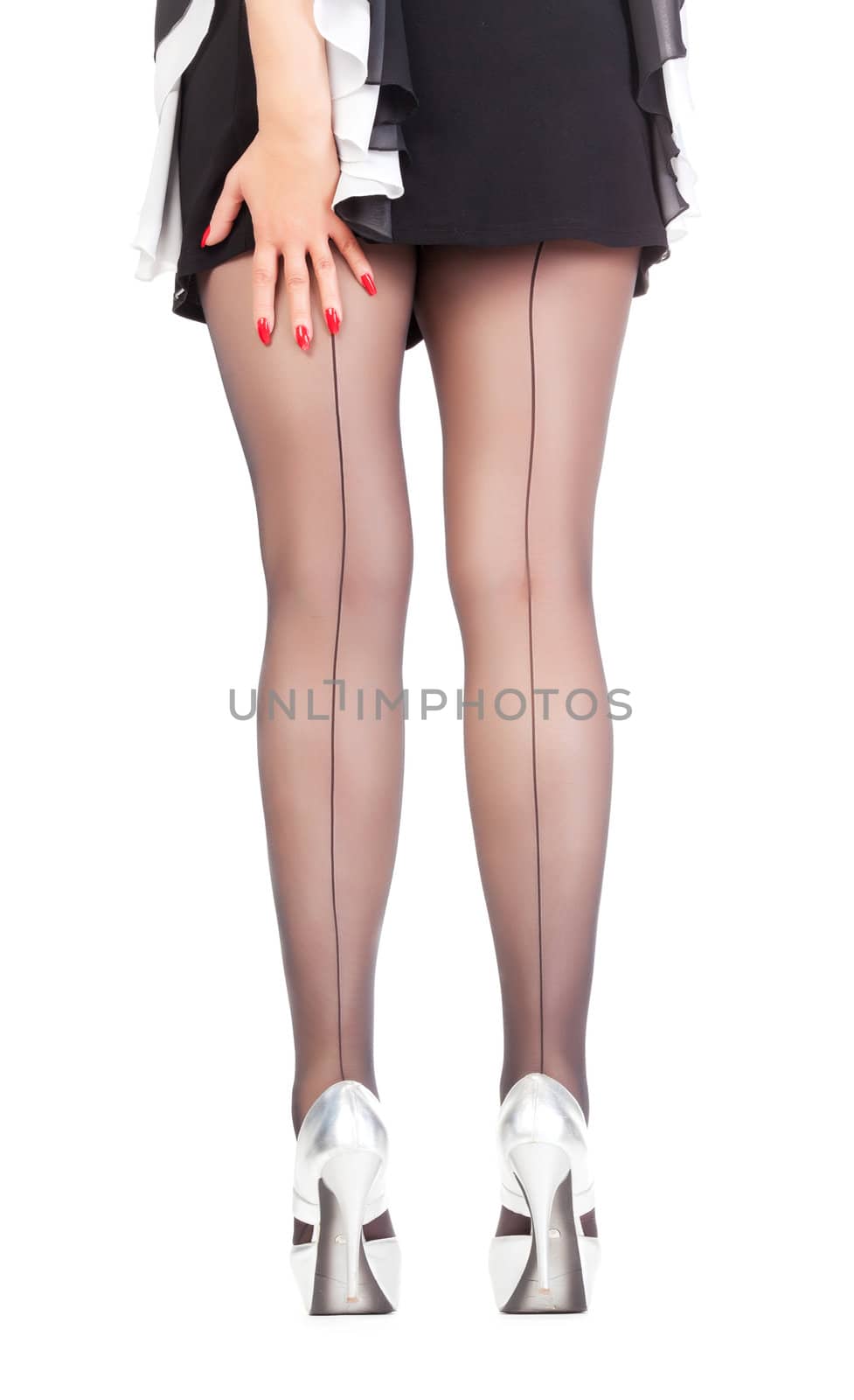Conceptual cropped view image of the sexy stylish legs of a female wearing black sheer stockings and fashionable stilettos