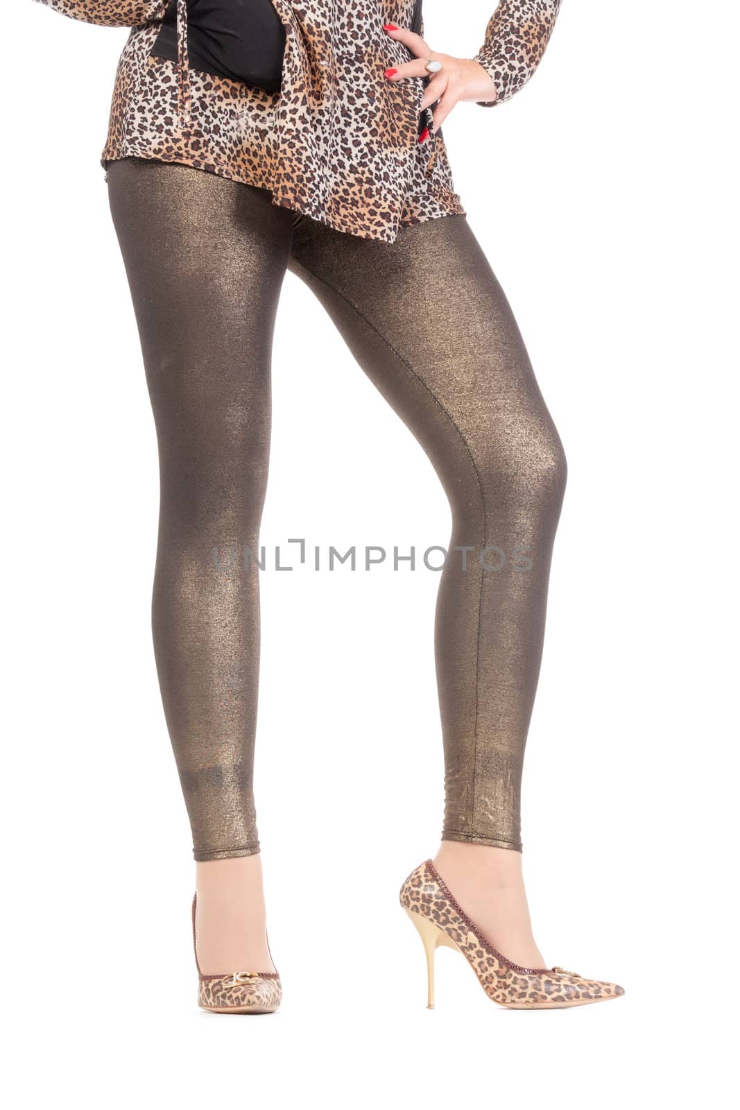 Cropped view image of a woman's sexy legs clad in shimmering golden leggins and stilettos