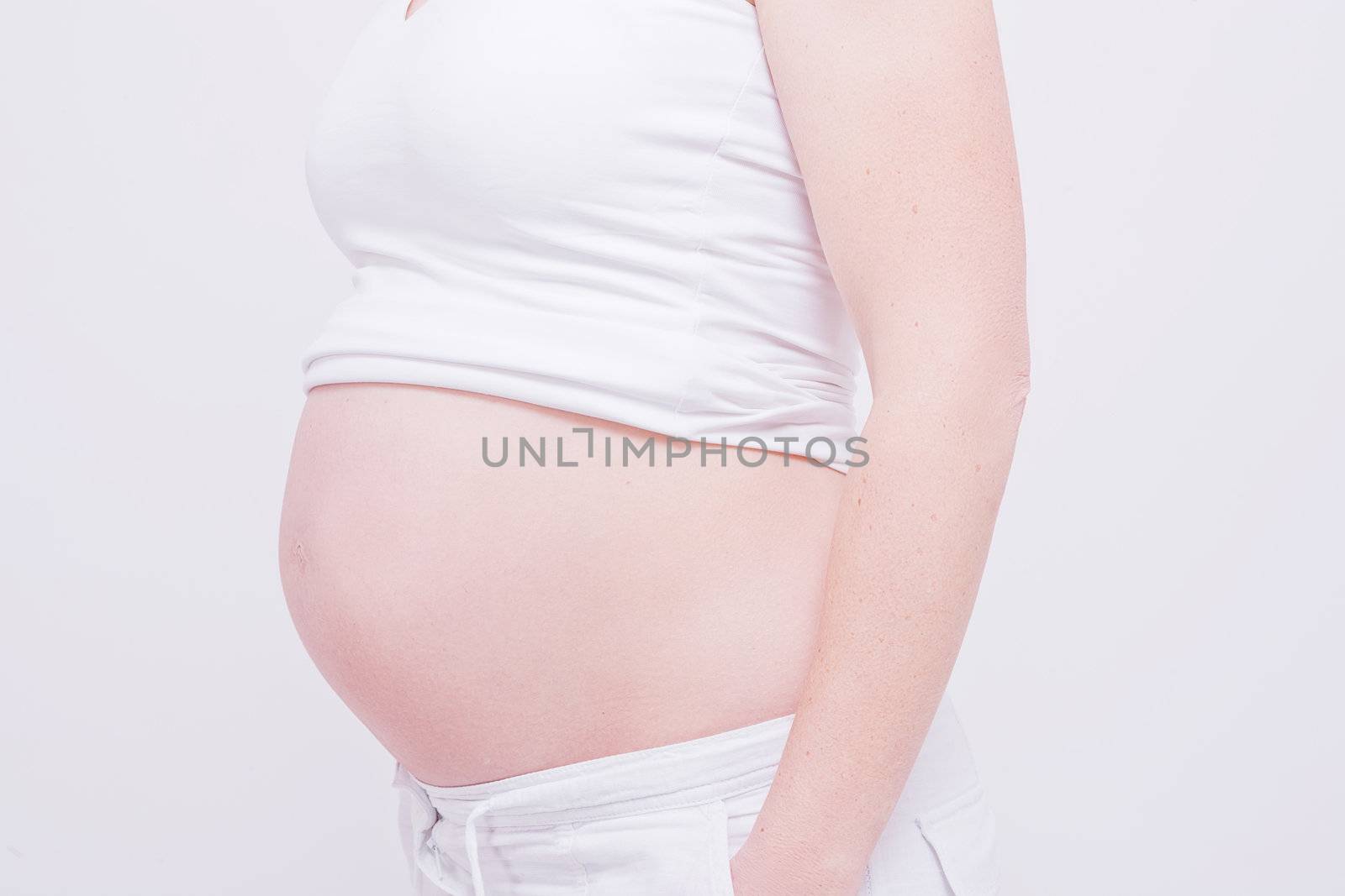 pregnant woman shows belly on white background