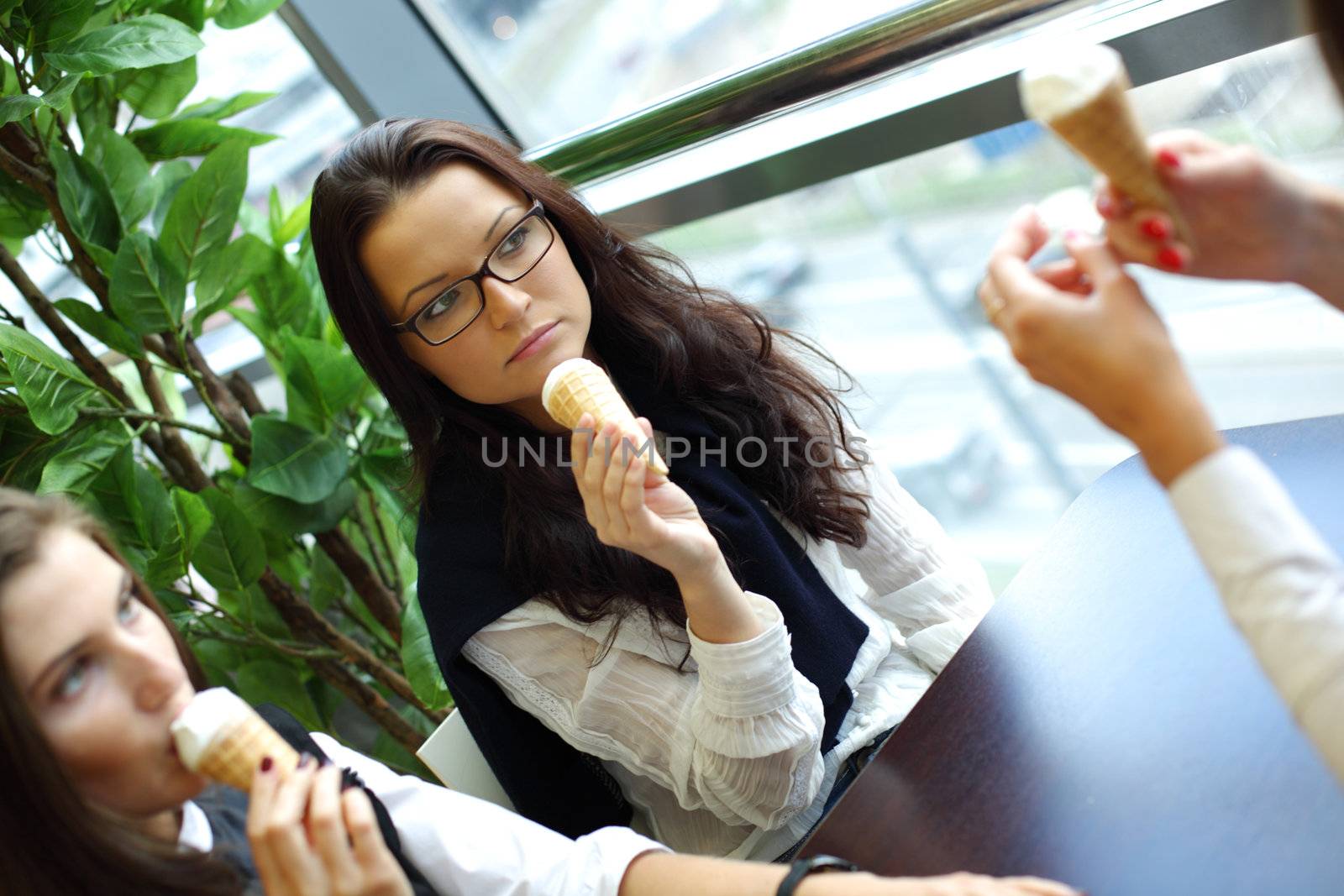 happy smiling women on foreground licking ice cream 