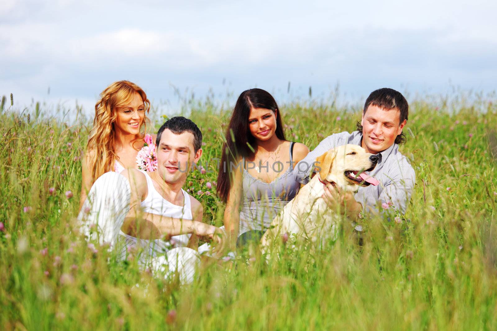 friends and dog in green grass field