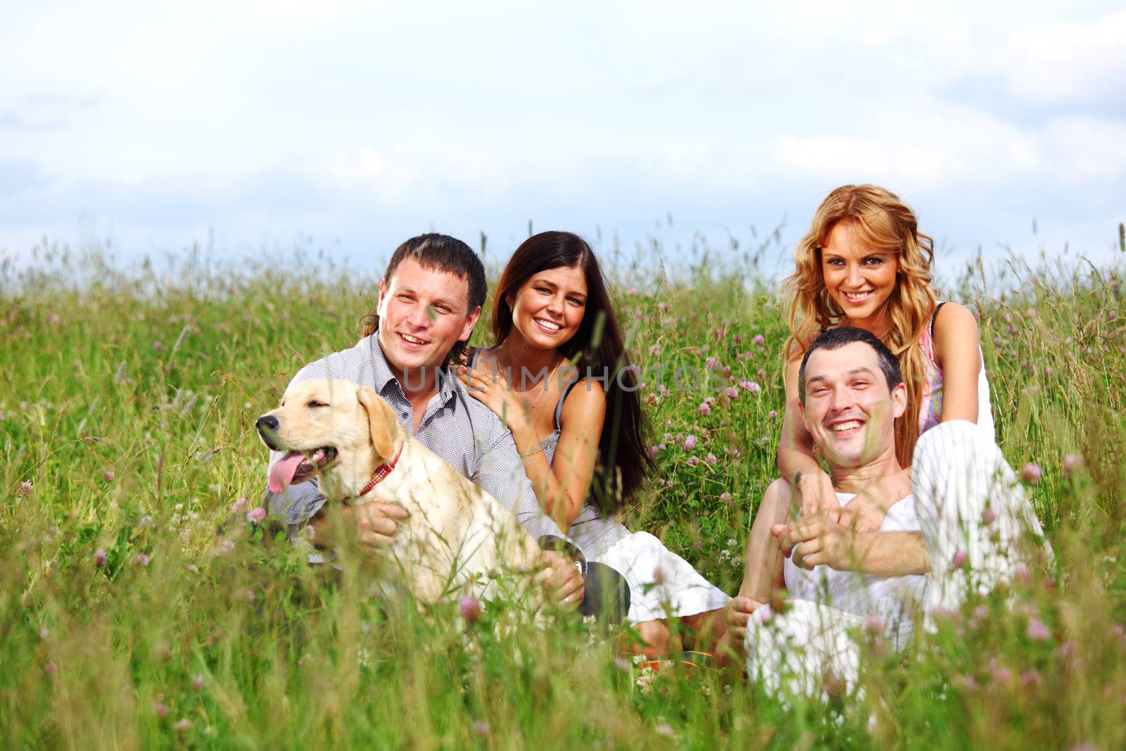 friends and dog in green grass field