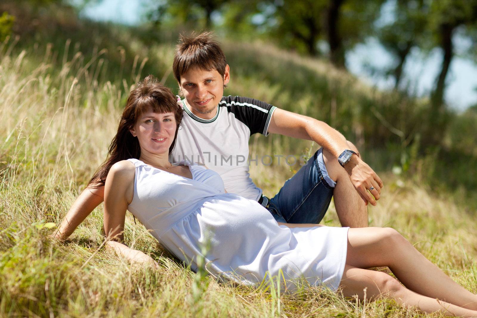 pregnant woman with husband on the grass