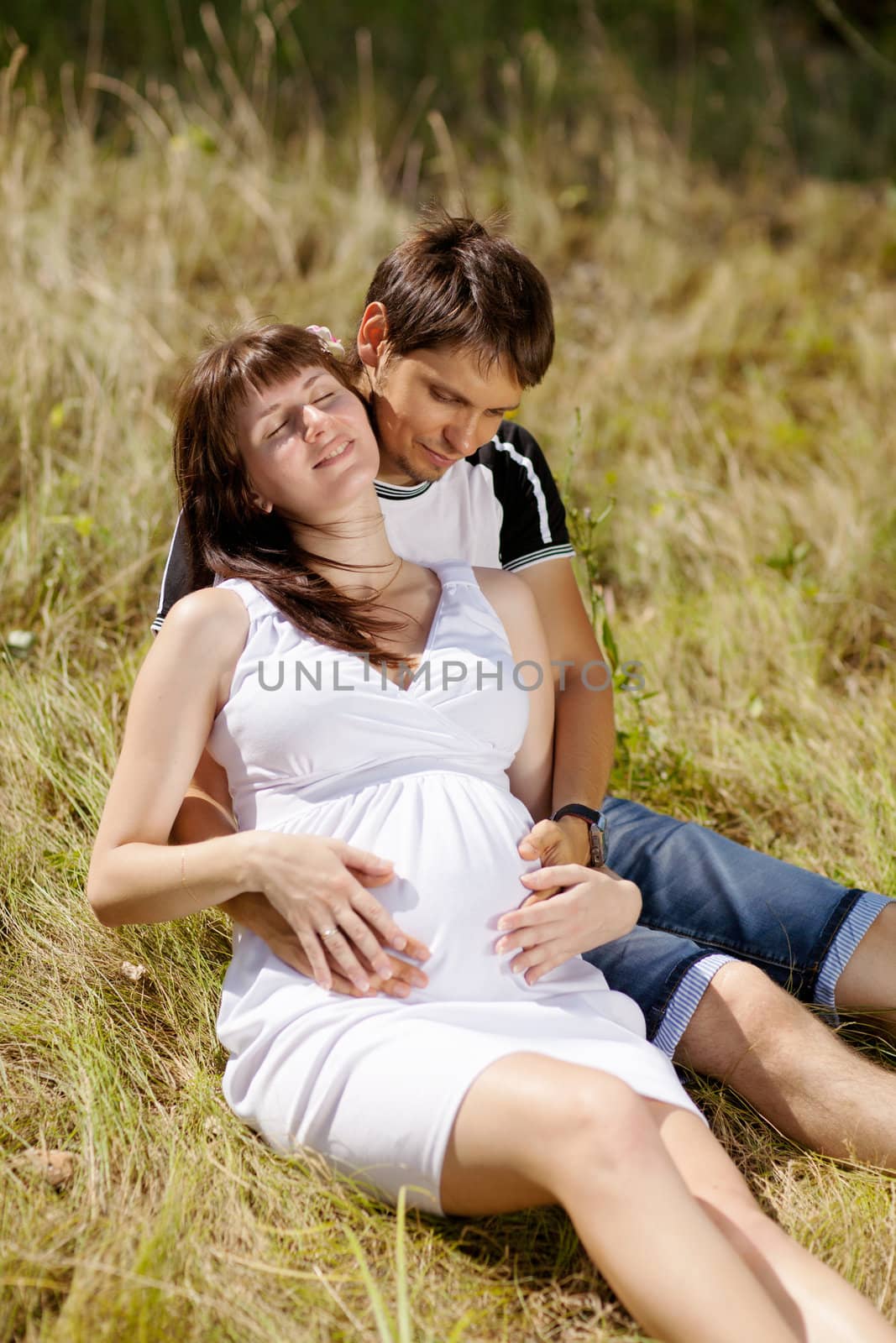 pregnant woman with husband on the grass