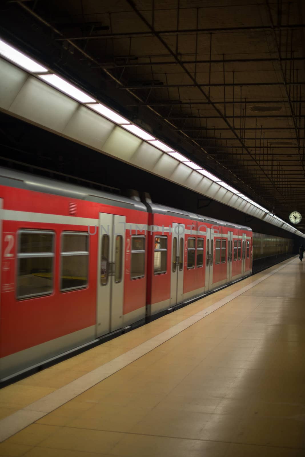 A subway train in motion arriving at an underground train station.