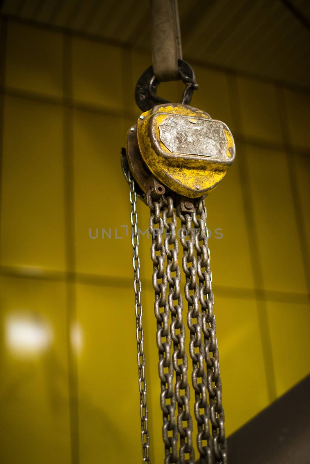 Industrial crane for lifting heavy load - vintage look with yellow background