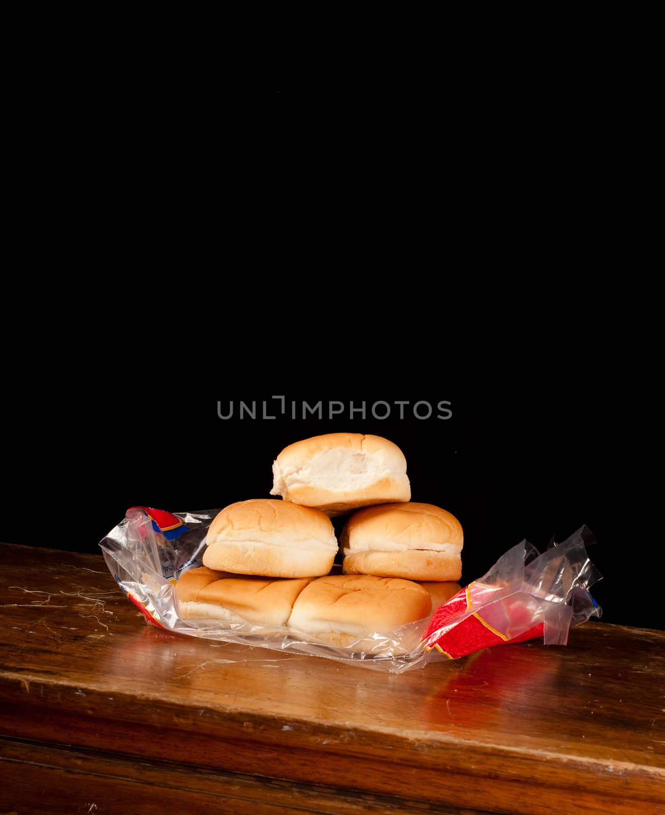 Package of hamburger buns on a wood plank