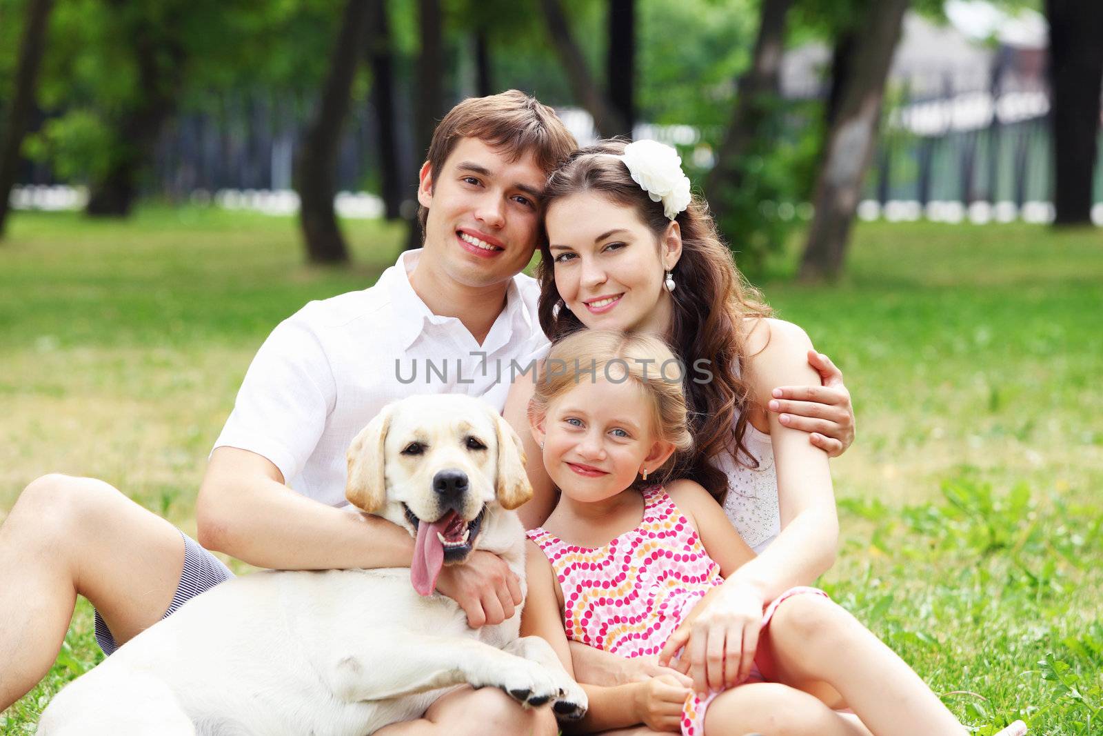 Young Family Outdoors in summer park with a dog