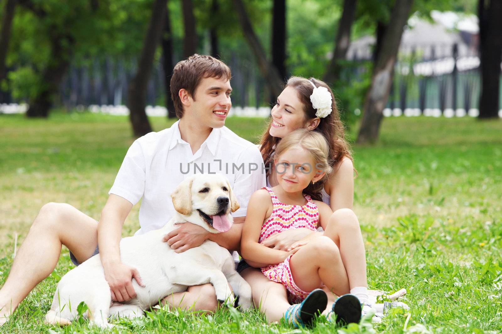 Young Family Outdoors in summer park with a dog