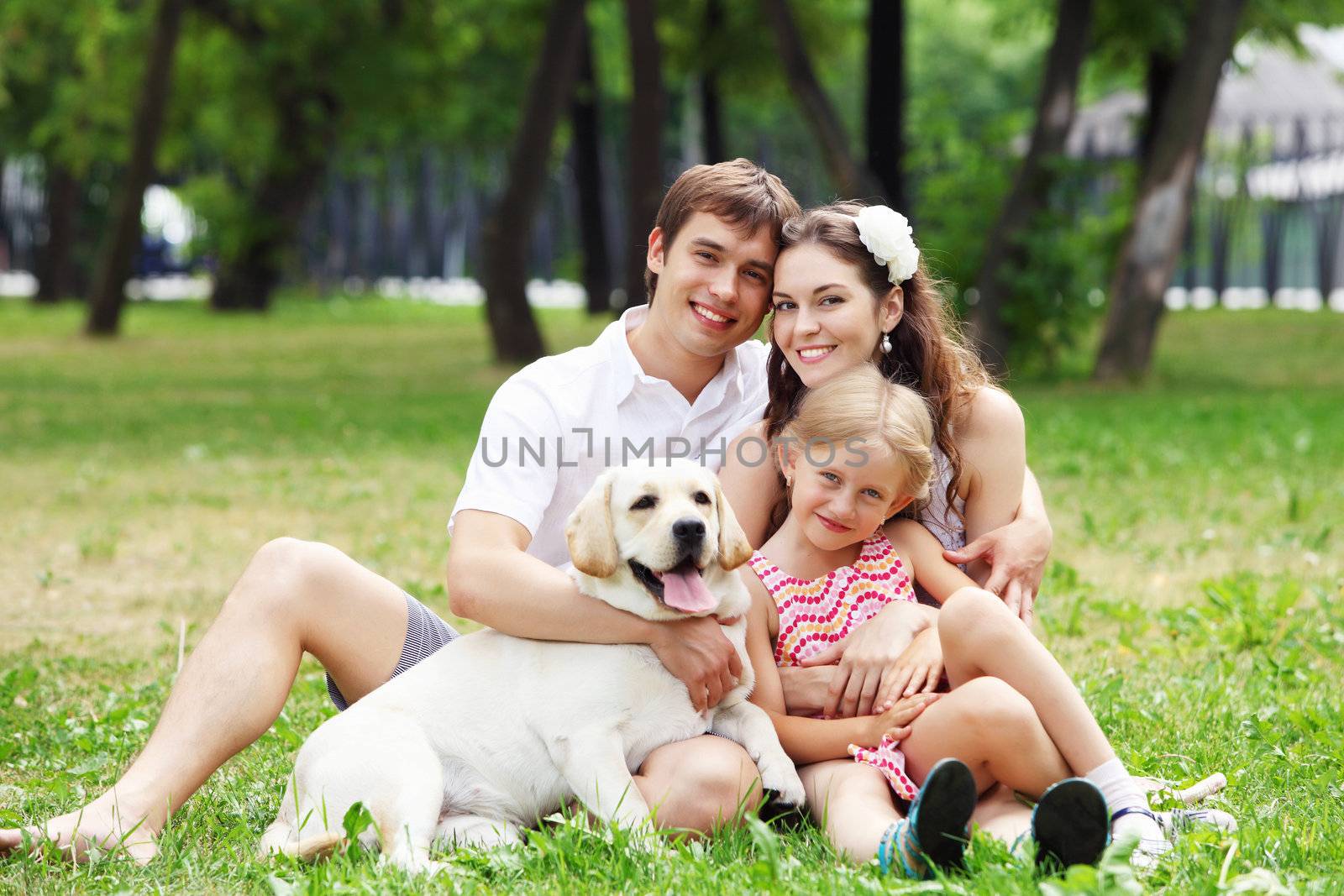 Young Family Outdoors in summer park with a dog