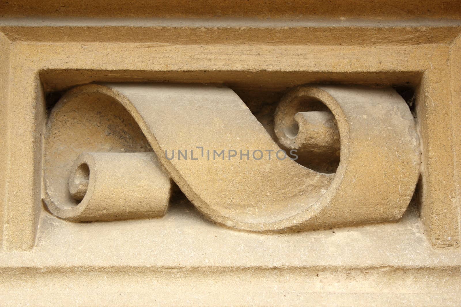 ribbon shaped detail carved in stone on facade of old house