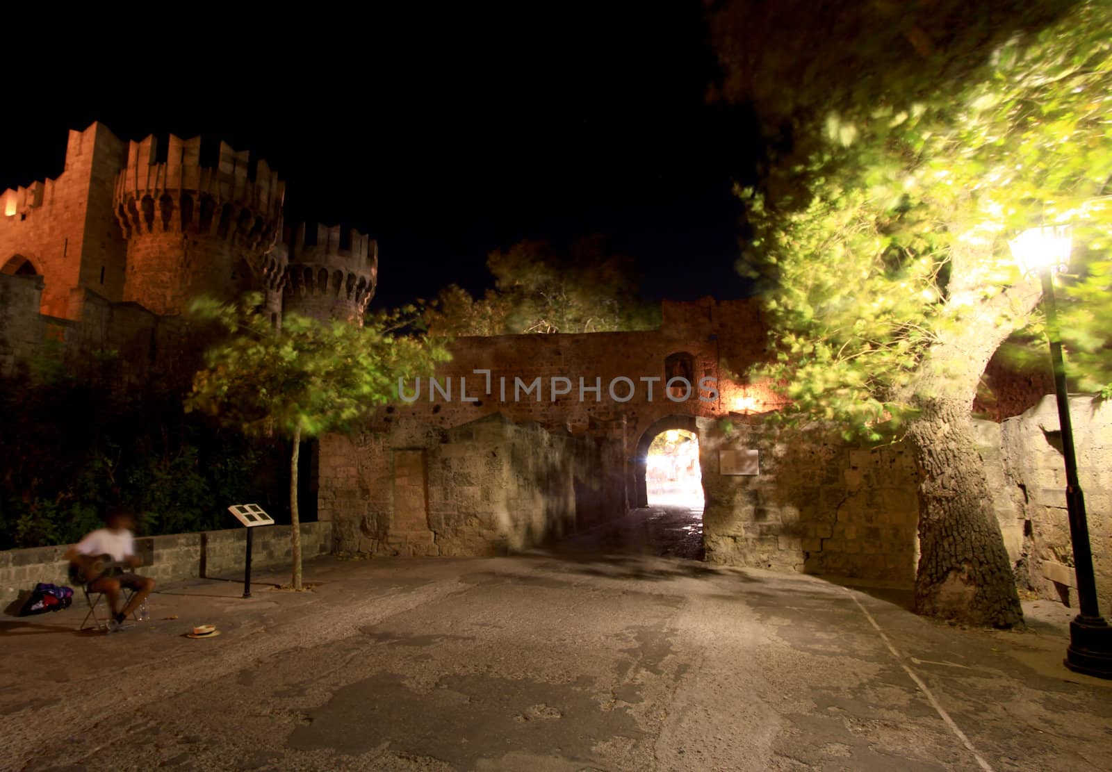A long exposure motion blurs a local buslter outside the Place of the Grand Masters in Rhodes