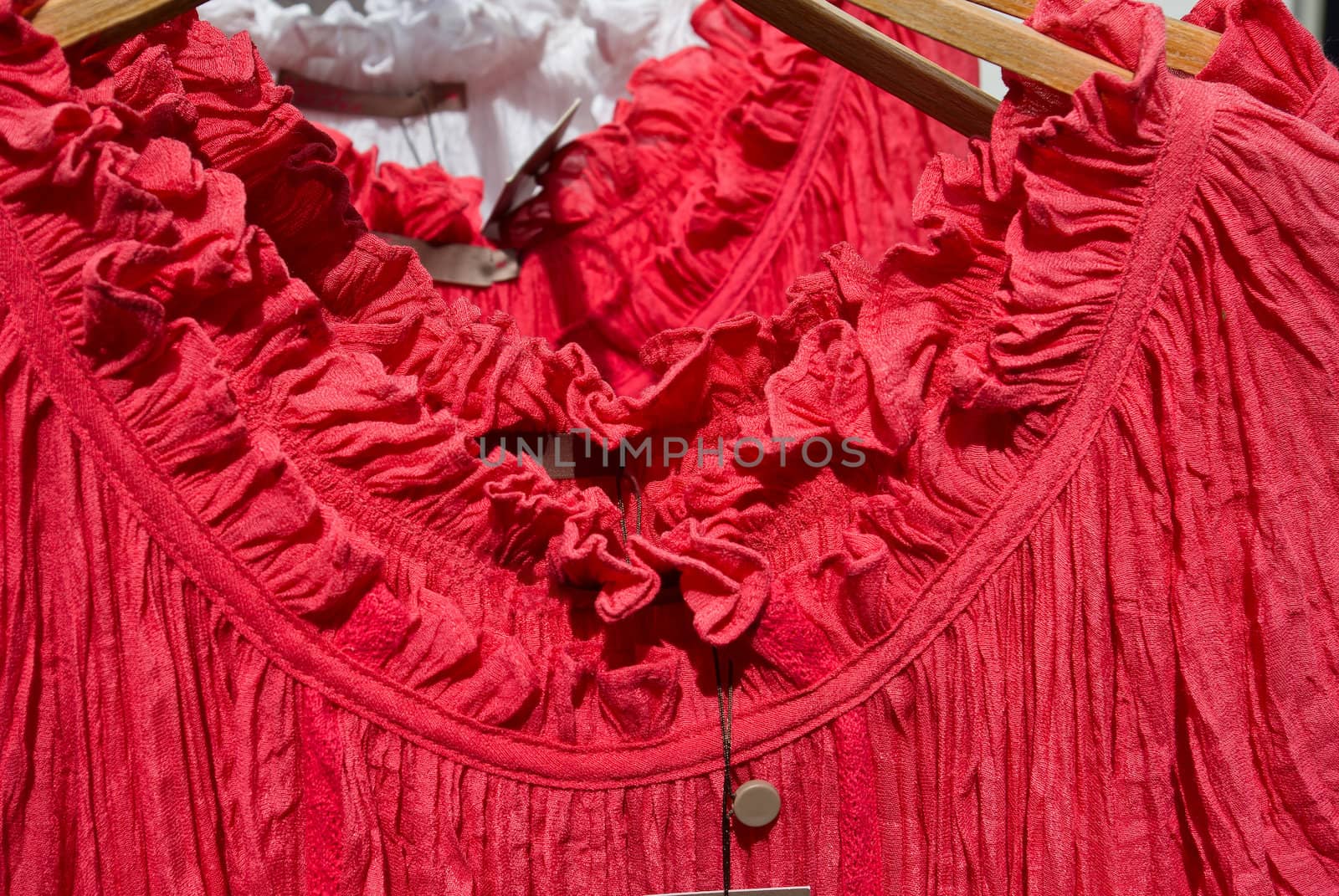 Woman red blouse top on wooden hanger in a fashion shop